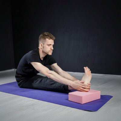 Brique de Yoga rose homme fait des exercices 